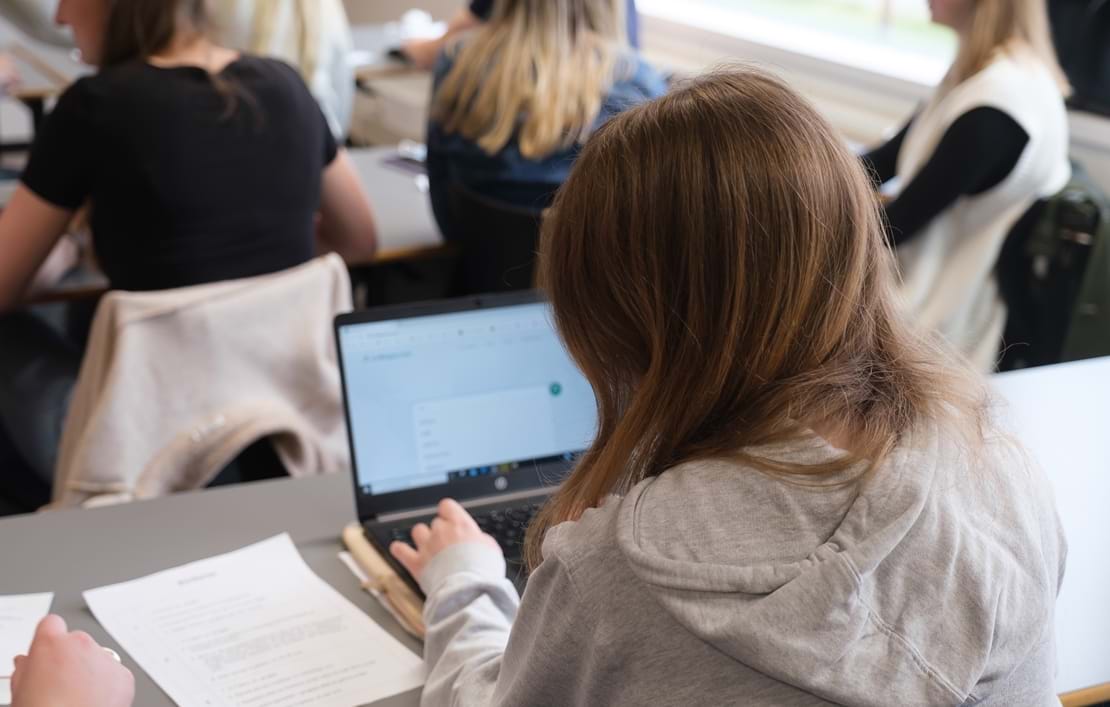 Pige arbejder på computer i klasseværelset