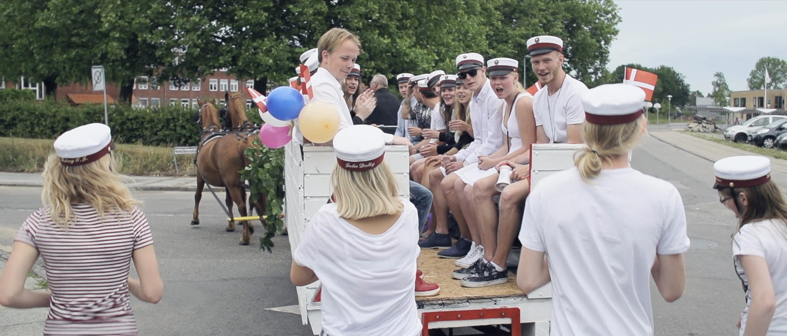 Glade studenter kører i hestevogn