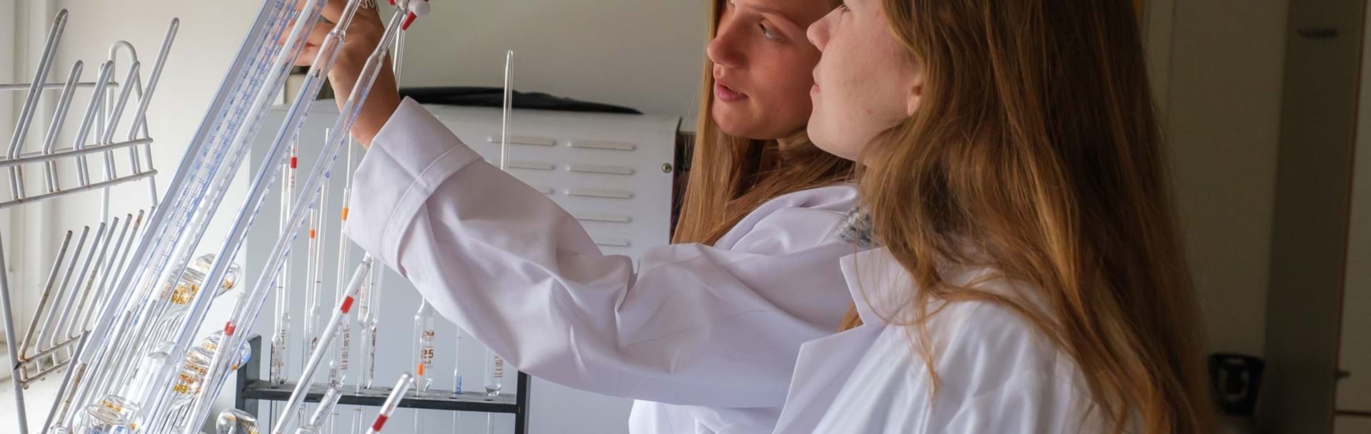 To piger arbejder i kemilokalet