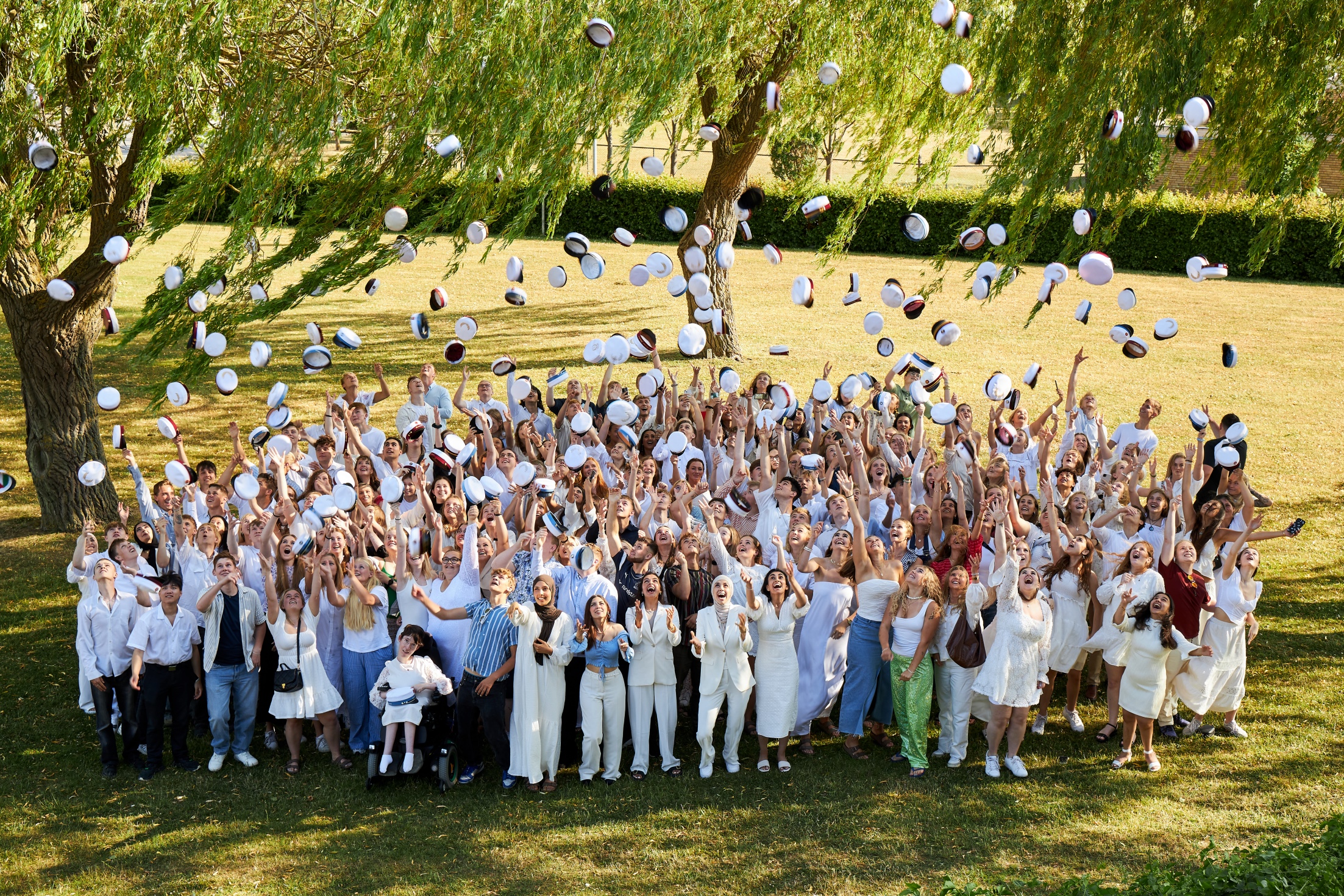 Studenter som kaster deres huer op i luften