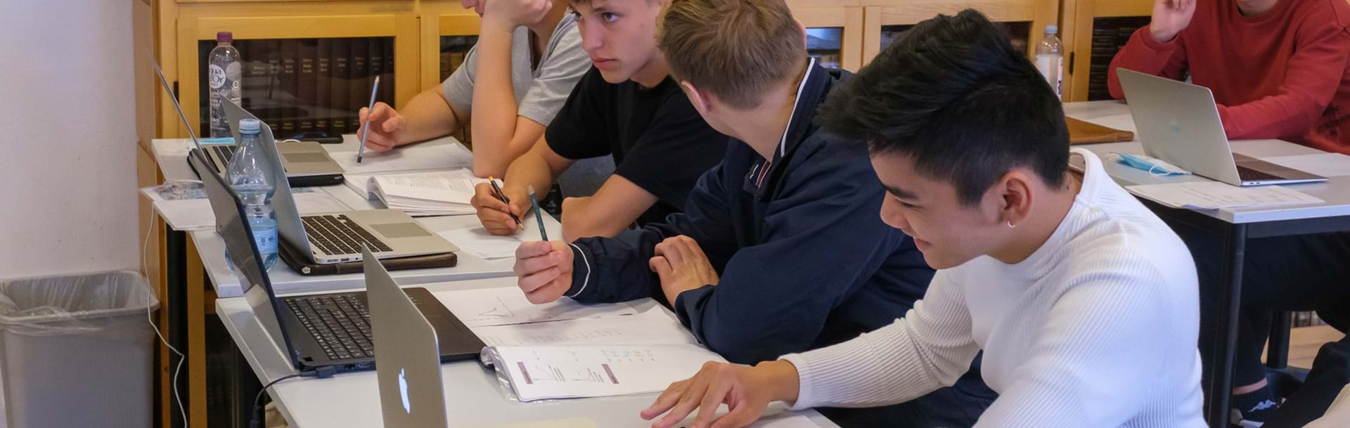 Fire HF elever sidder ved siden af hinanden i klasselokalet