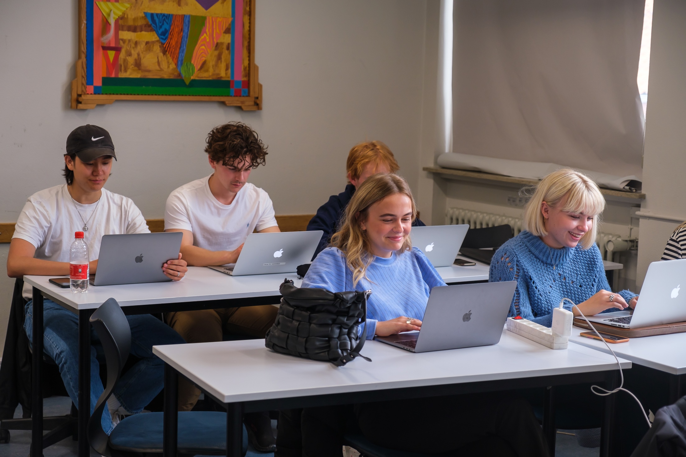 Elever arbejder på dere computere i klasselokalet