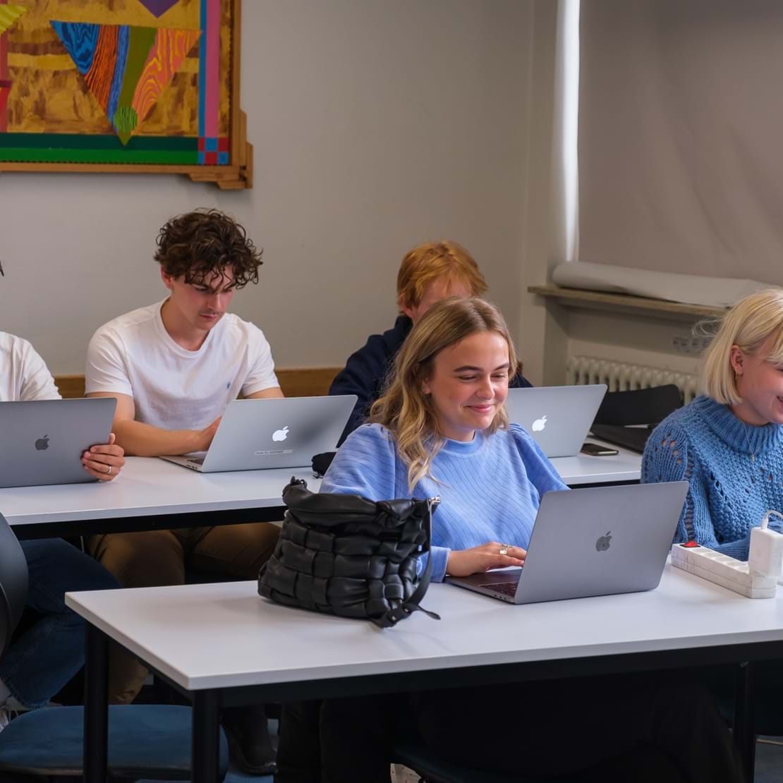 Elever arbejder på dere computere i klasselokalet