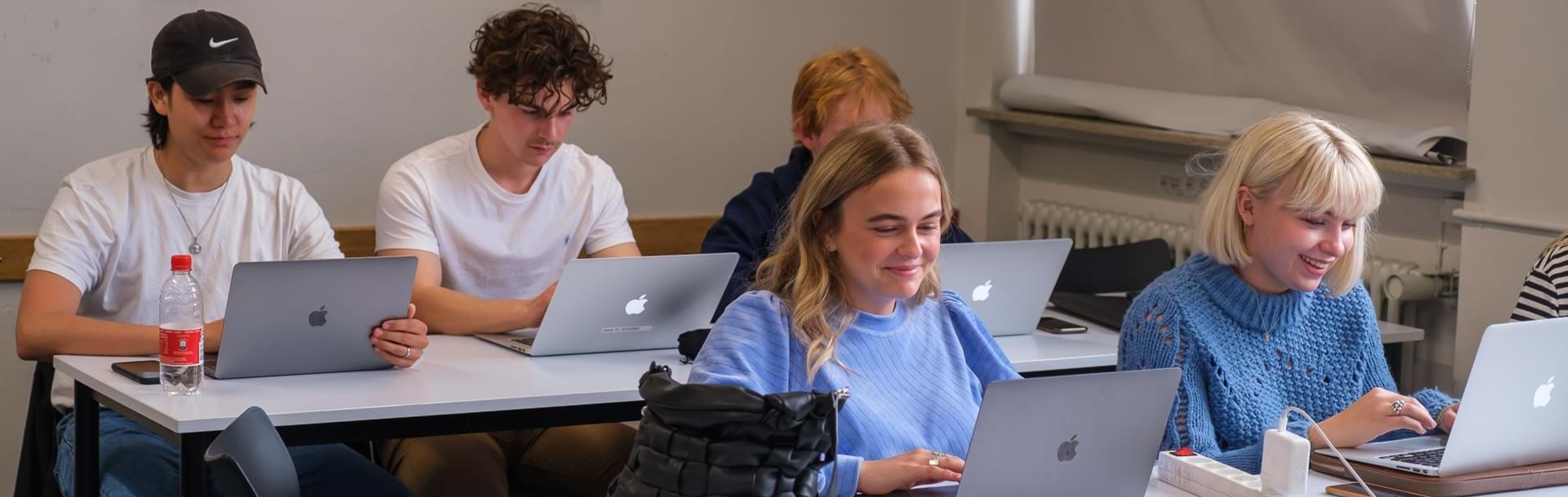 Elever arbejder på dere computere i klasselokalet