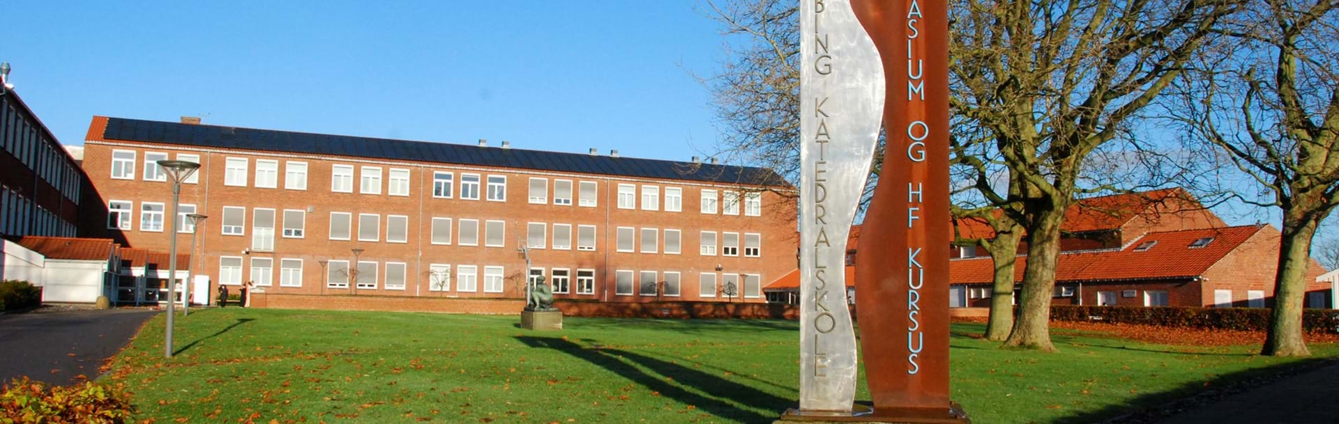 Nykøbing Katedralskole set udefra i baggrunden og skulptur i forgrunden