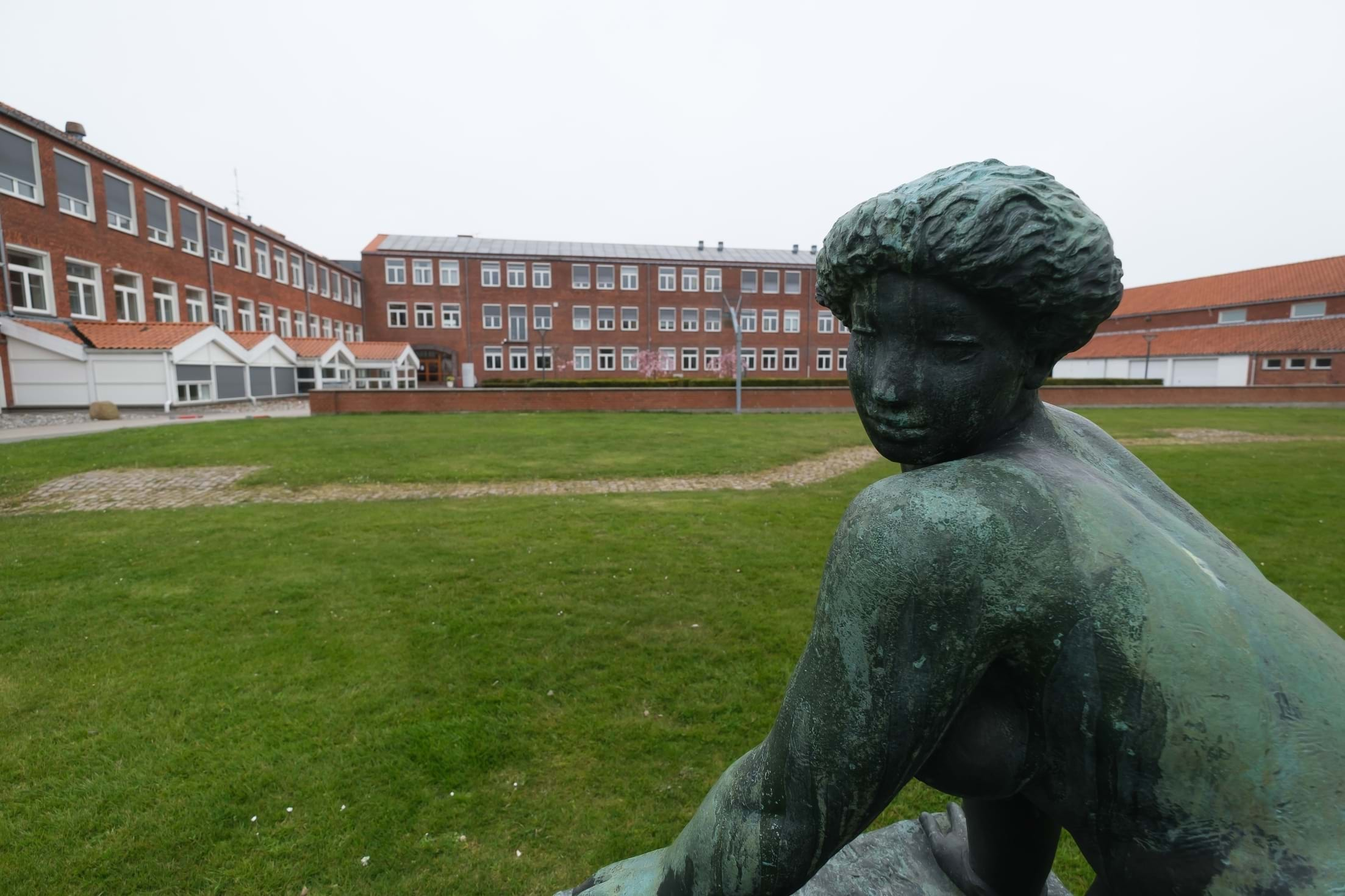 Nykøbing Katedralskole uskarp i baggrunden og statue i fokus i forgrunden