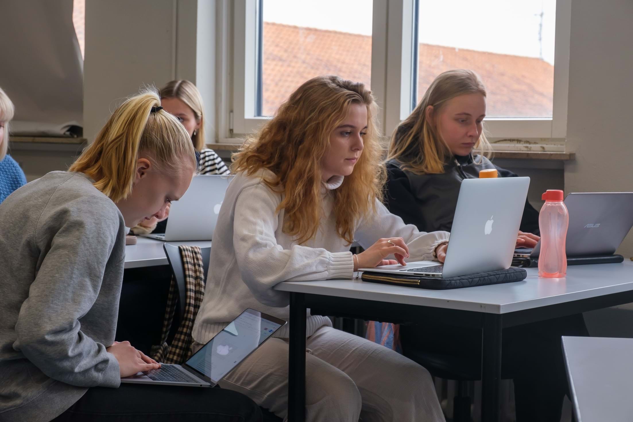 Elever arbejder på deres bærbare computere i klasseværelset