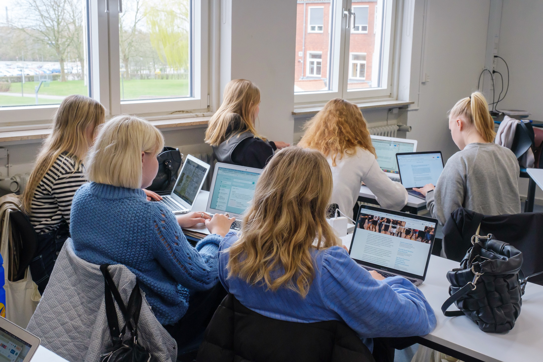 Elever i klasselokale som alle sidder med computere