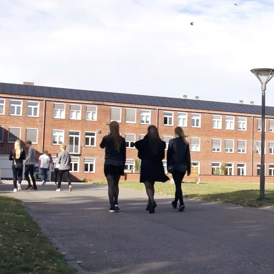 Tre elever på vej ind på skolen.